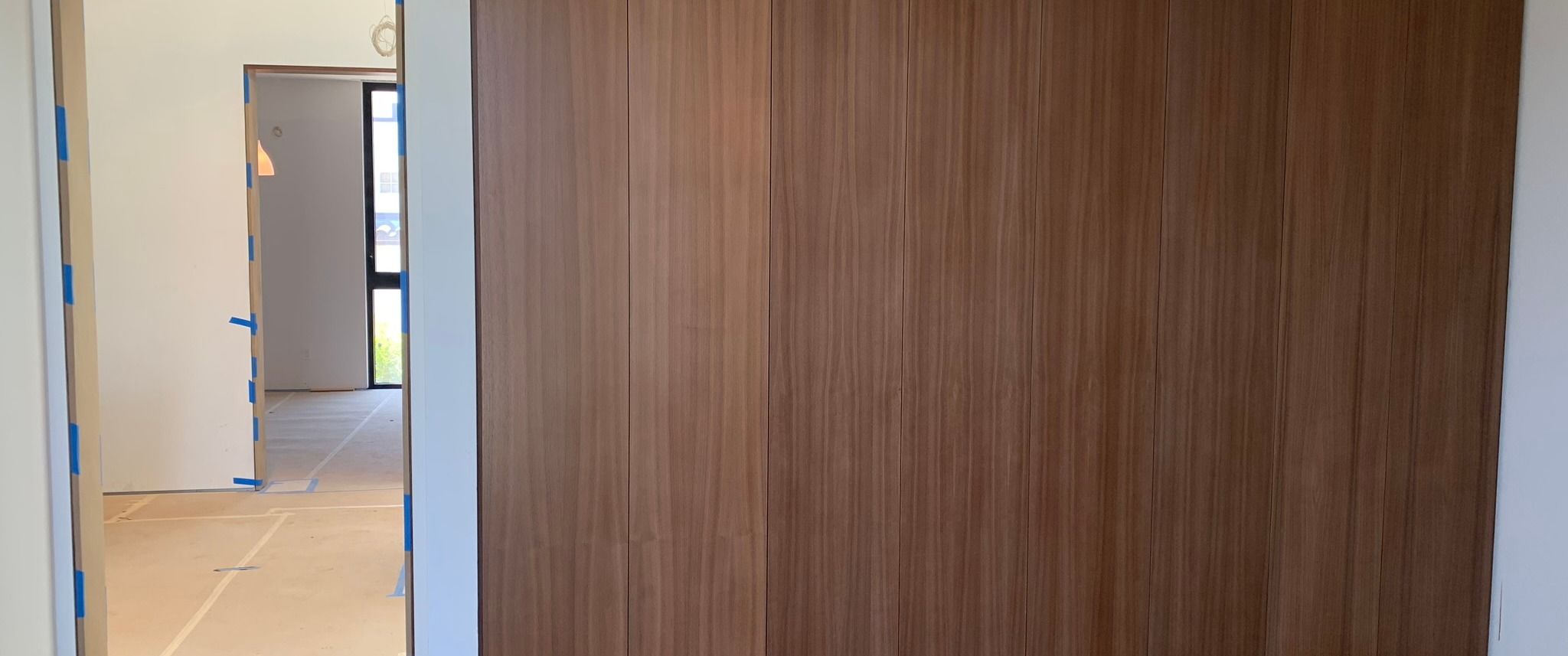 Rift-oak paneling meeting a trimless flush opening, reveal set to a hairline, as built