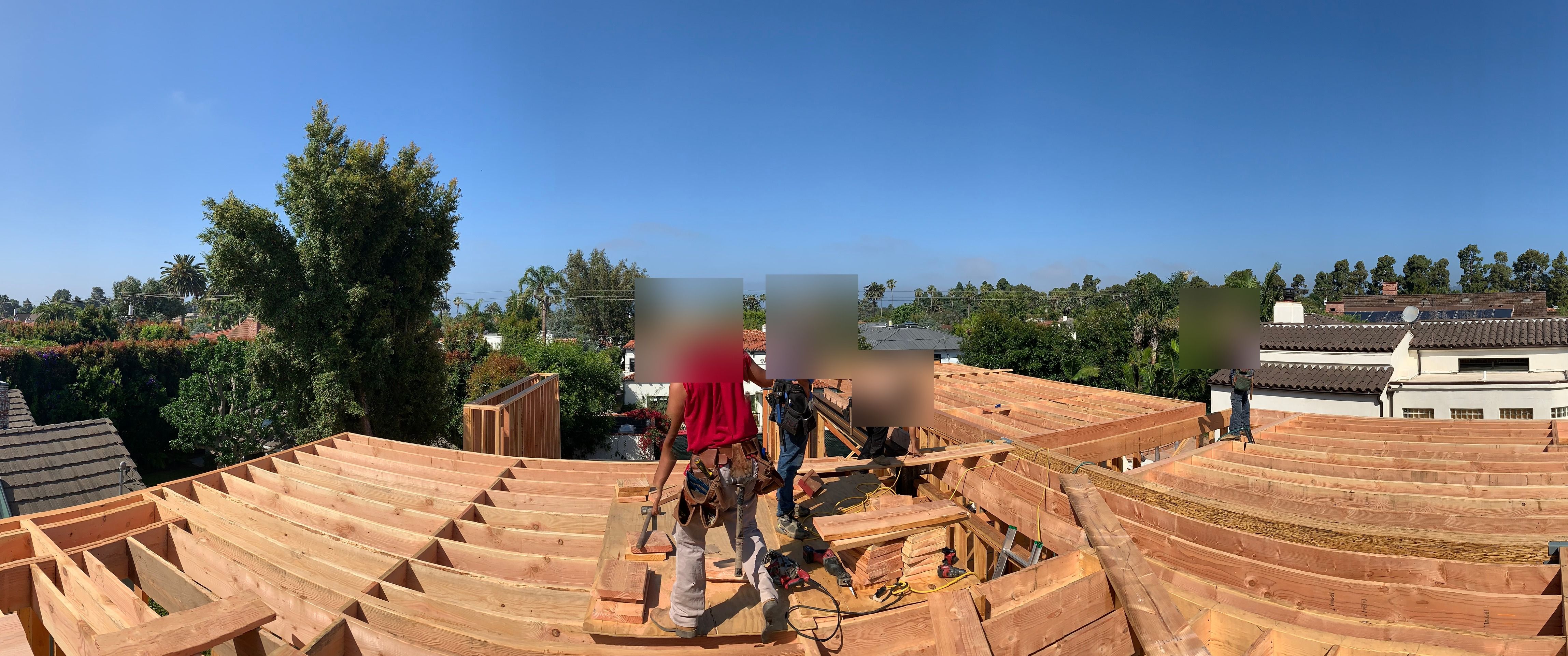Akopi Builders crew on an active roof-framing build in Santa Monica, worker faces obscured for privacy